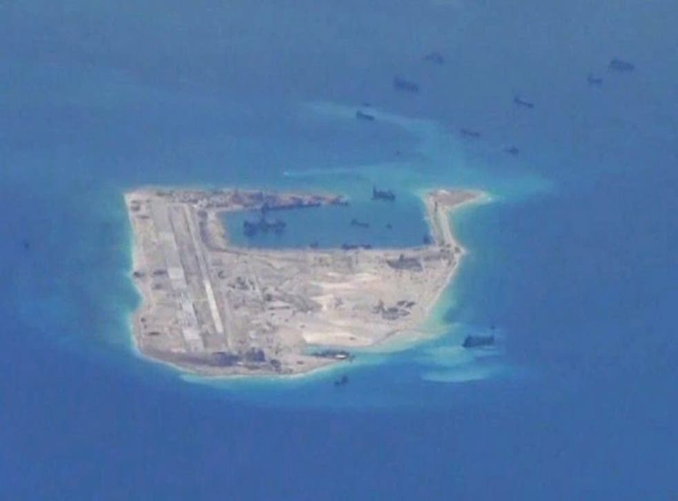 Chinese dredging vessels are purportedly seen in the waters around Fiery Cross Reef in the disputed Spratly Islands in the South China Sea in this still file image from video taken by a P-8A Poseidon surveillance aircraft provided by the United States Nav