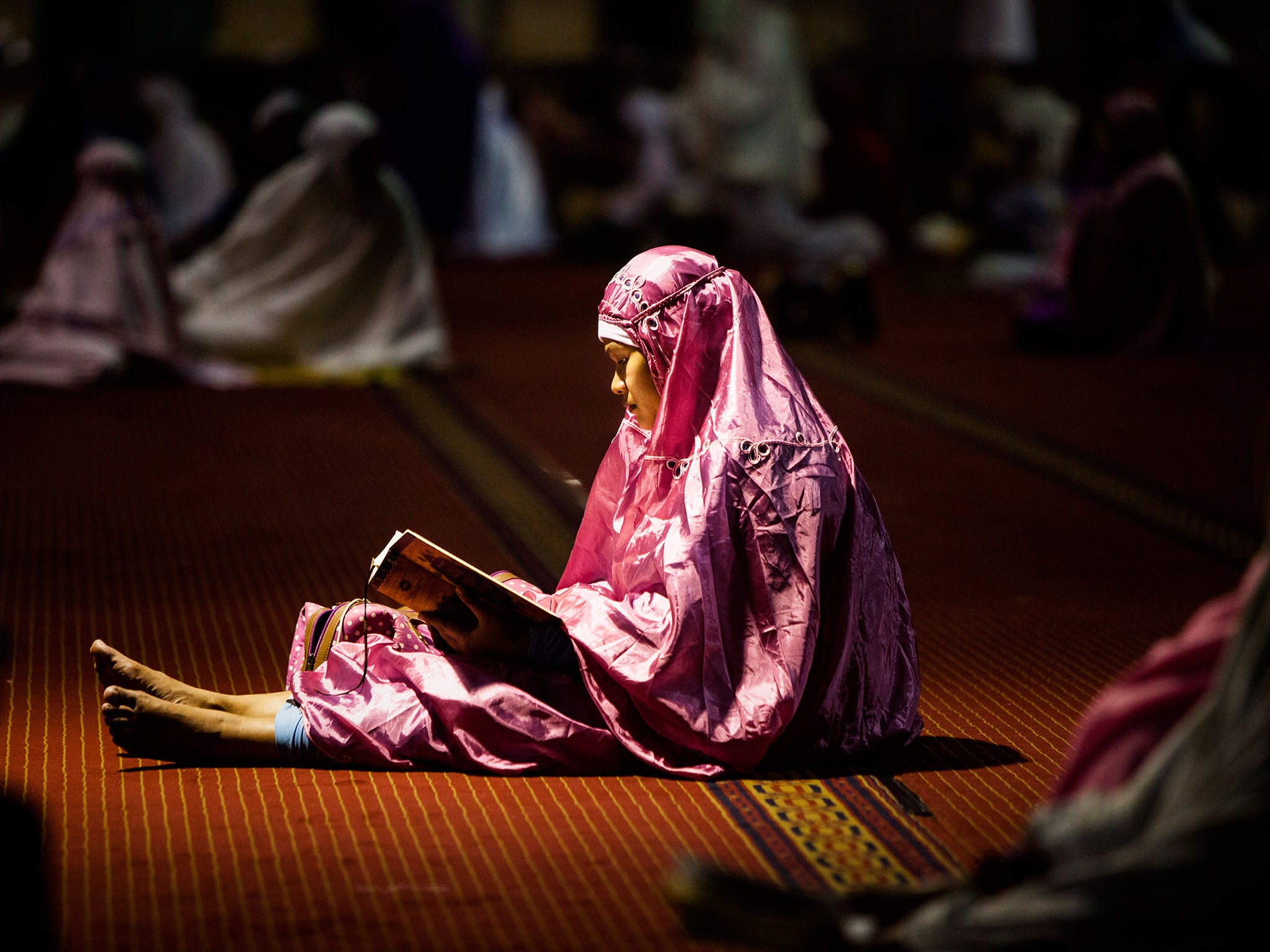 A Indonesian woman reads the Koran on the first day of Ramadan