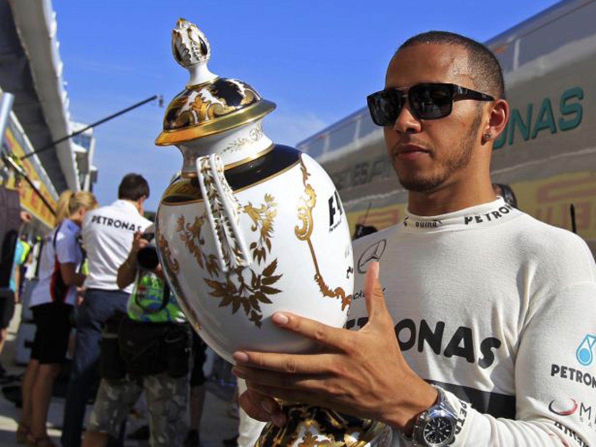 Lewis Hamilton kisses his trophy on the podium
