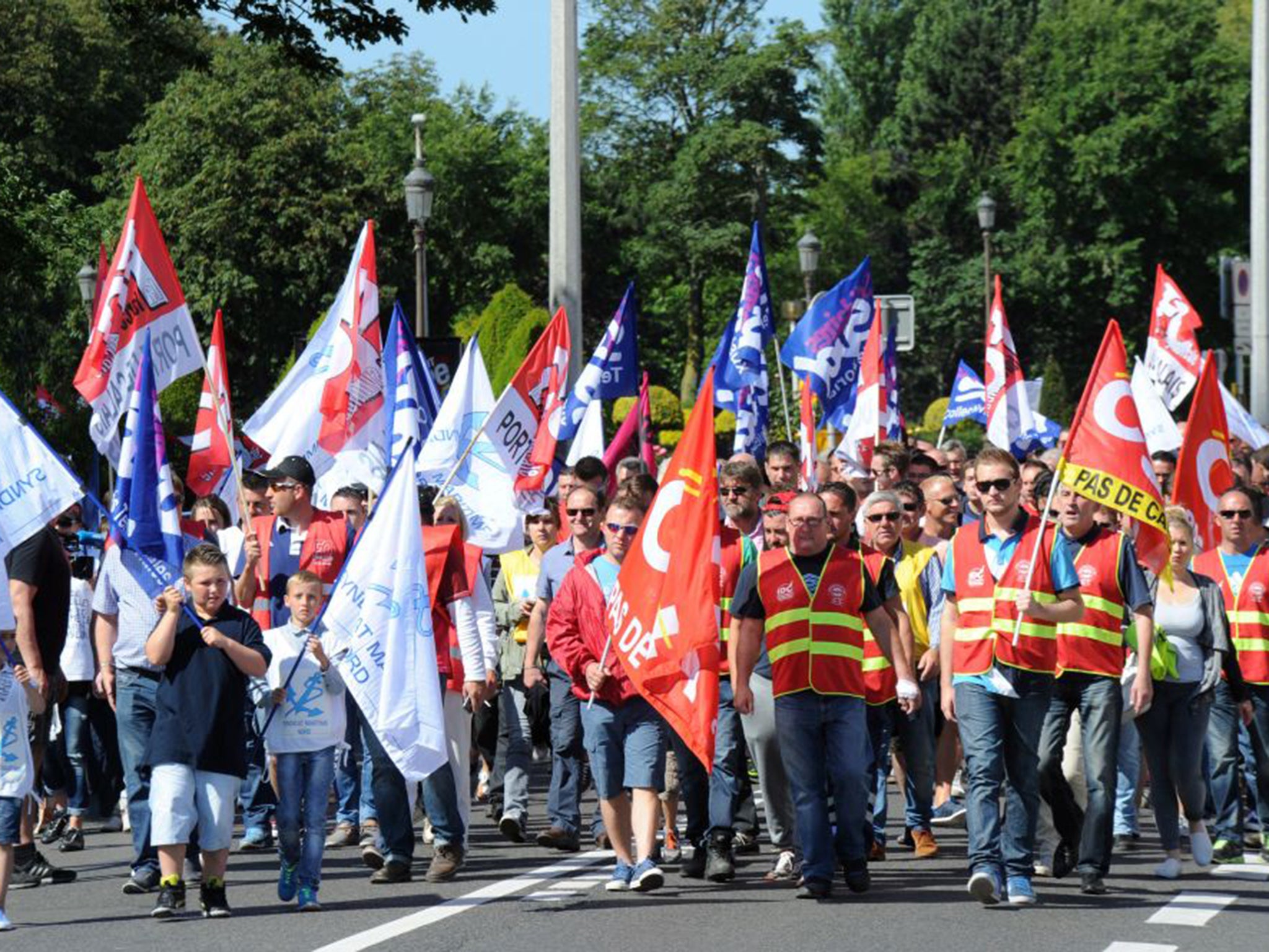 People wave French labour union flags in support of the employees of Scop, which operates three ships via the cross-channel ferry company MyFerryLink