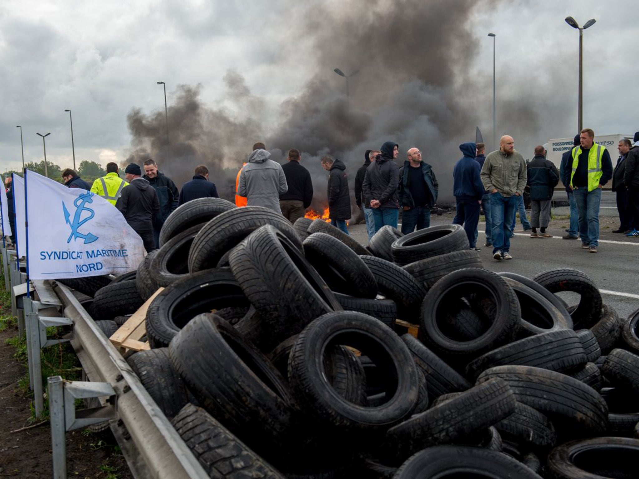 MyFerryLink workers beside tyres set on fire to block access to the Channel Tunnel