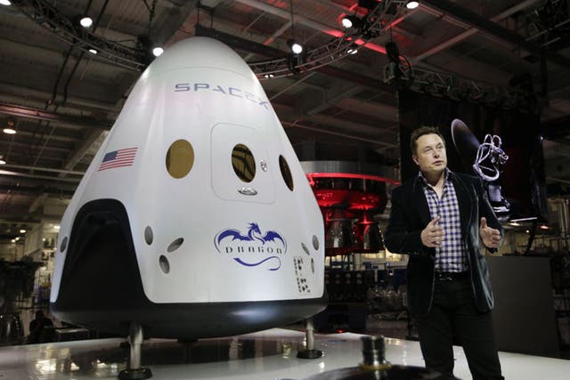 Elon Musk with a SpaceX rocket. Will his gamble on commercial space transport pay off?