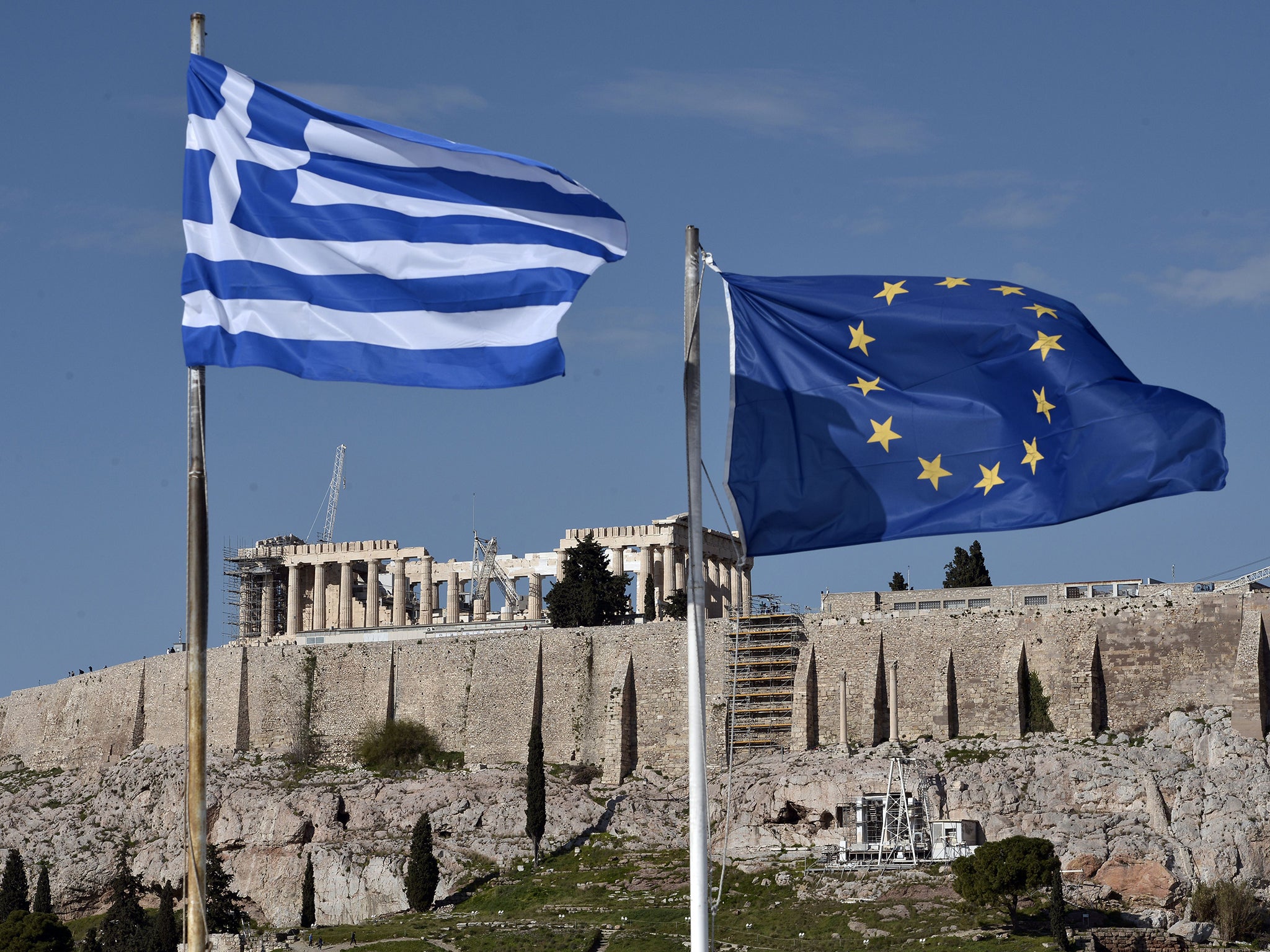 The Greek and EU flags flutter in front of the ancient Acropolis hill in Athens. The Greek people have been called upon to show “calm and national unity”