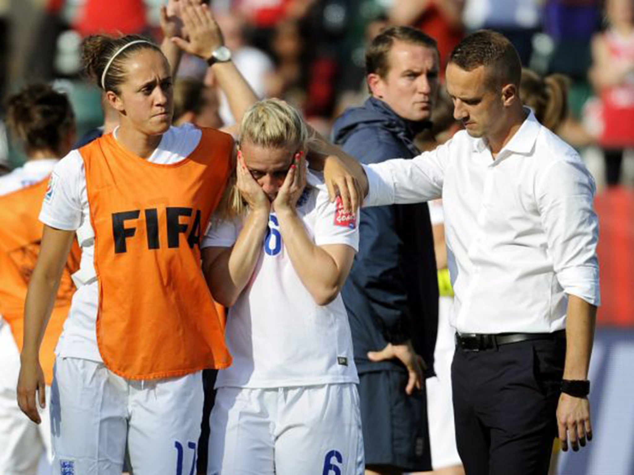 England coach Mark Sampson consoles a tearful Laura Bassett, centre, after their semi-final defeat to Japan