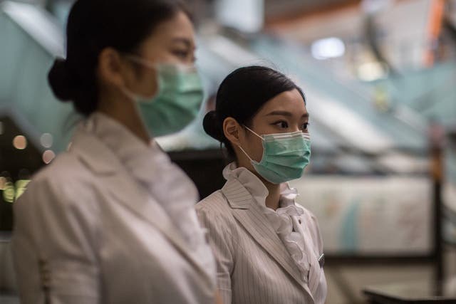 Members of staff wear face masks at Kowloon station in Hong Kong on 27 June 2015, after a 17-year-old Korean man with a fever sought medical care at a clinic in the station and has since been isolated in hospital where he is being tested for MERS, accordi