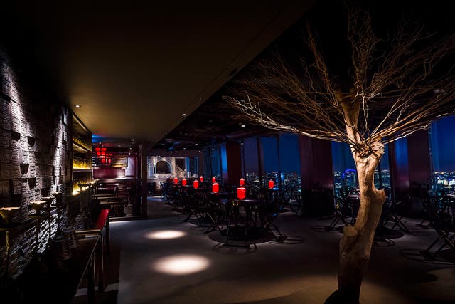 Inside Hutong, it's all sexy gloom, with dark-wood panelling lit with red lanterns