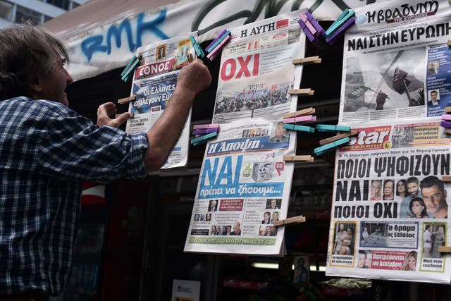 Yes and No… Newspapers with opposing headlines are put up in Athens