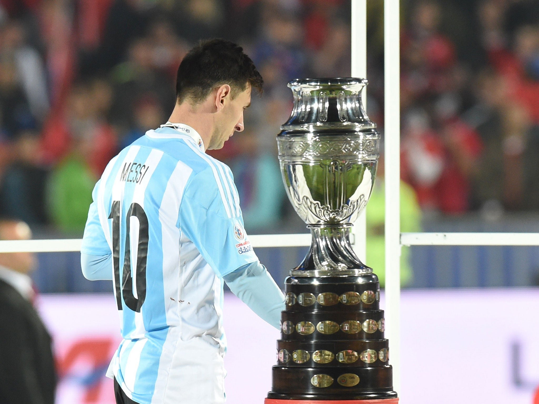 Beaten finalist Lionel Messi walks past the Copa America trophy