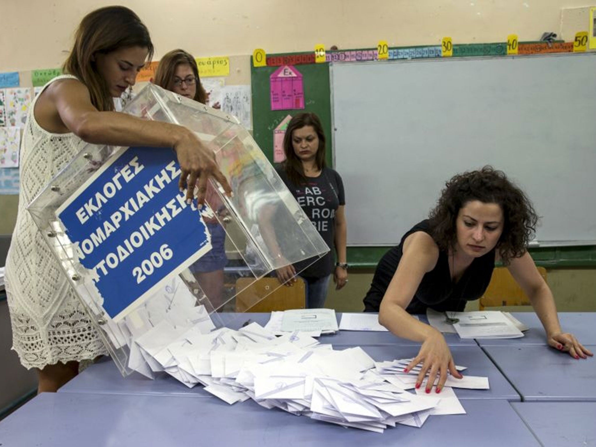 A ballot box is emptied by a voting official at the closing of polling stations in Athens, Greece July 5, 2015. Greece voted on Sunday on whether to accept more austerity in exchange for international aid, in a high-stakes referendum likely to determine w