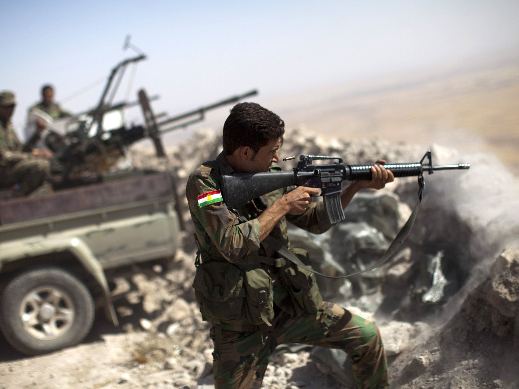 A Kurdish Peshmerga fighter fires at Isis militants in Mount Zaidar, near Mosul, Iraq