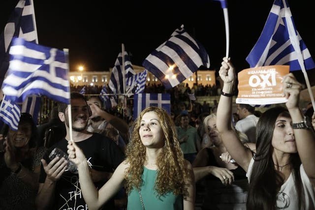 epa04832814 Supporters of the 'No' campaign wave flags and react after the first results of the referendum at Syntagma Square, in Athens, Greece, 05 July 2015. Greek voters in the referendum were asked whether the country should accept reform proposals ma