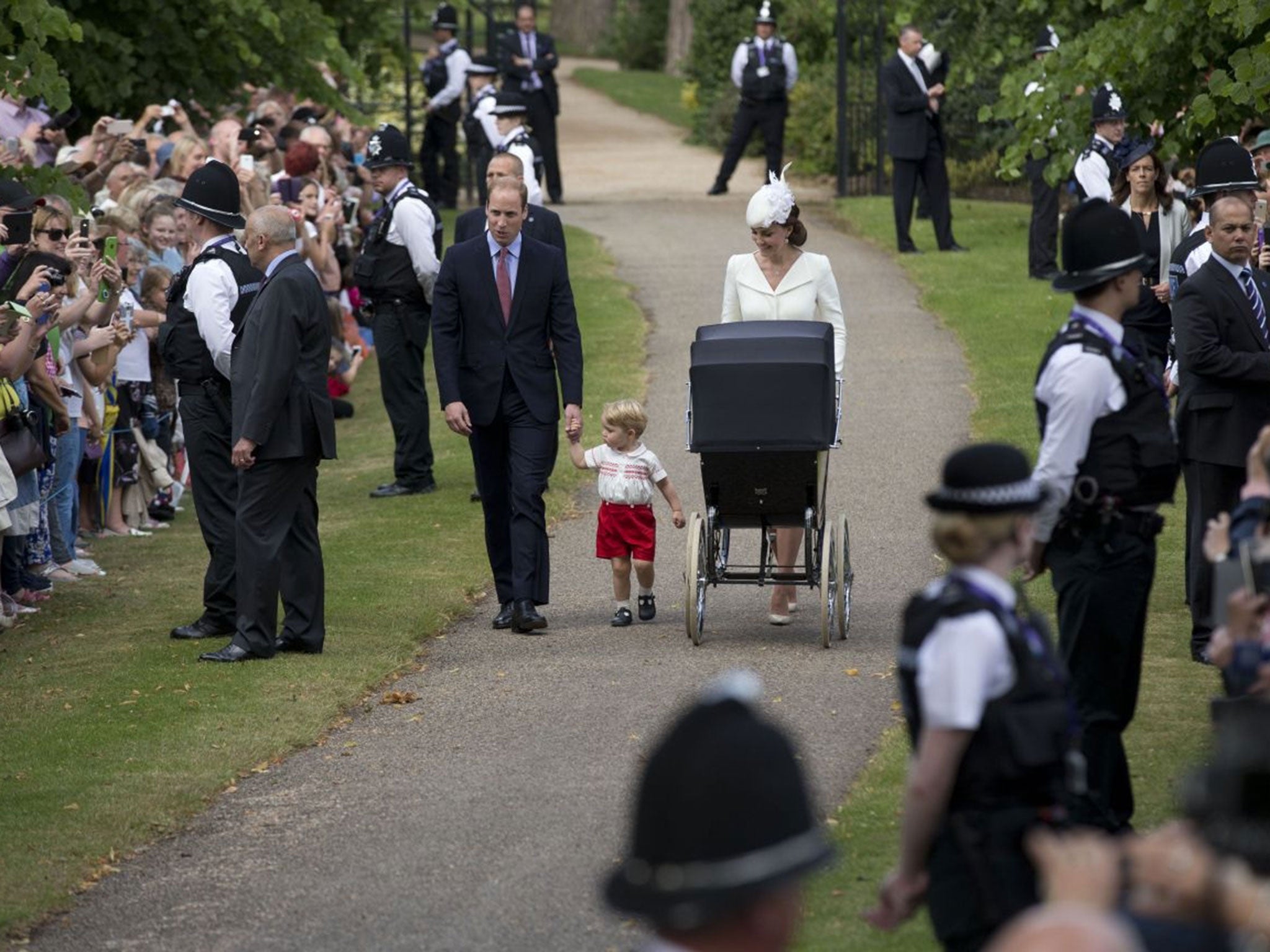 The Duke and Duchess of Cambridge, their son Prince George and daughter Princess Charlotte in a pram arrive for Charlotte's Christening