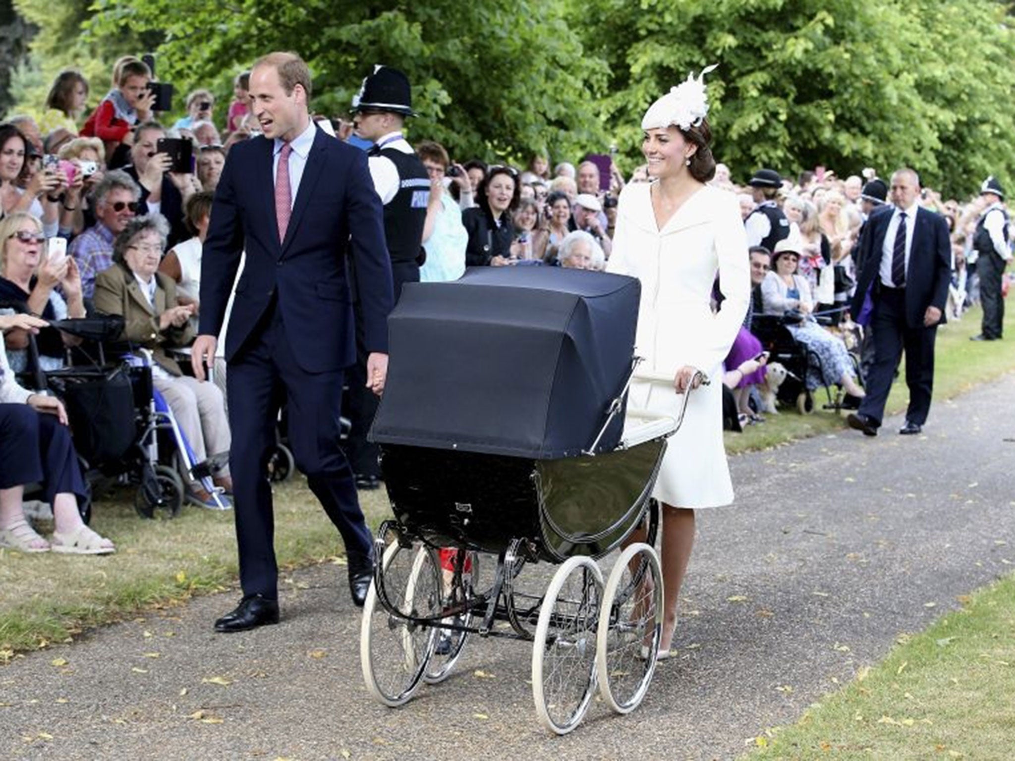 The Duke and Duchess of Cambridge walk past well wishers as they arrive with their son Prince George and daughter Princess Charlotte for her christening at the Church of St. Mary Magdalene in Sandringham