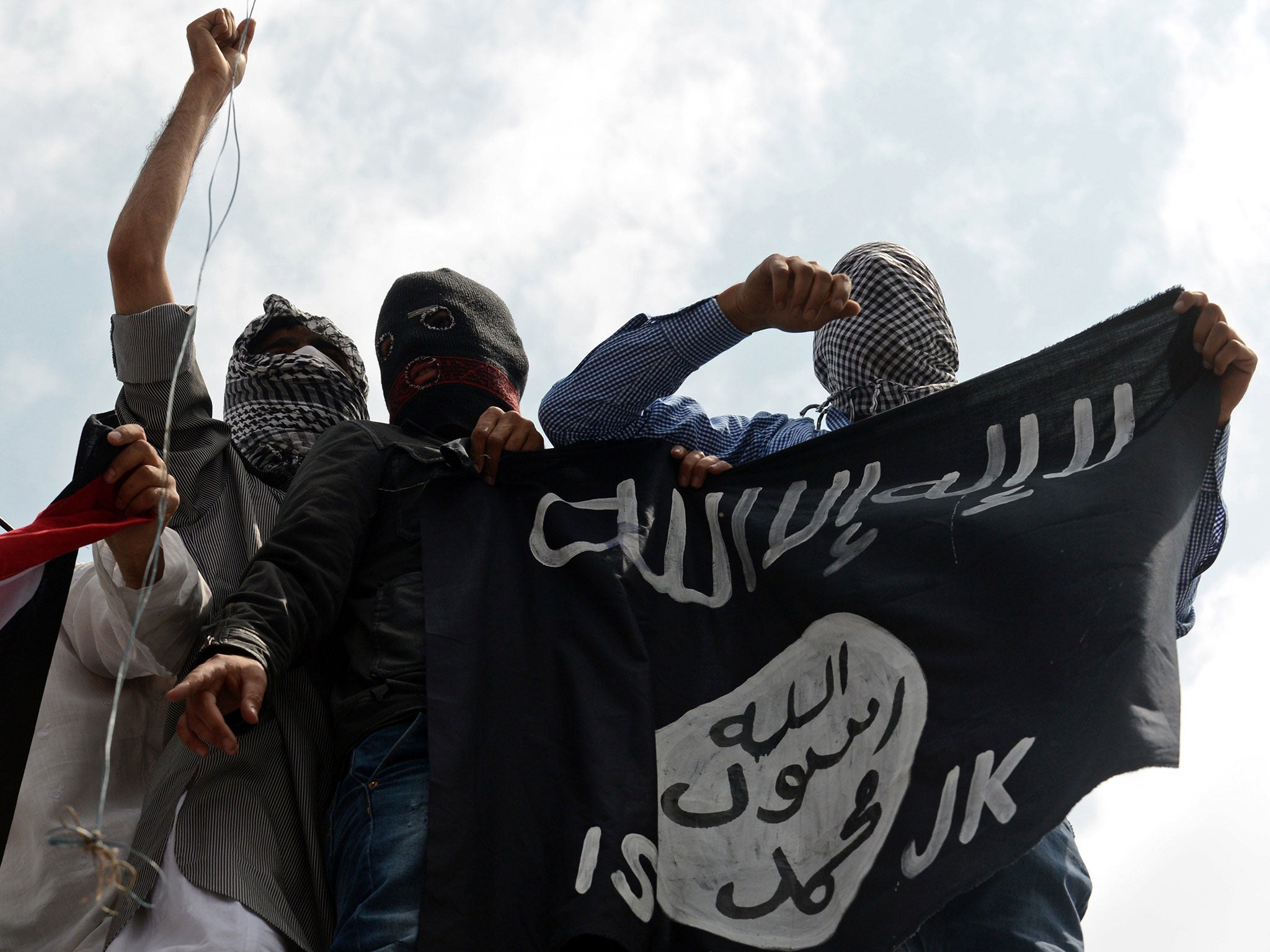 Kashmiri demonstrators hold up a flag of Isis