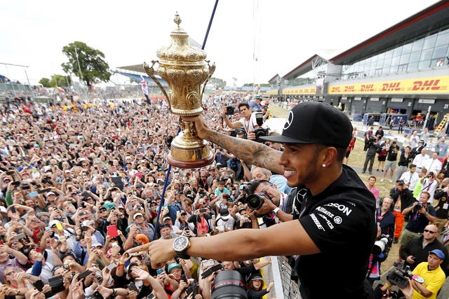 Lewis Hamilton shows his delighted fans the British Grand Prix trophy after his victory at Silverstone