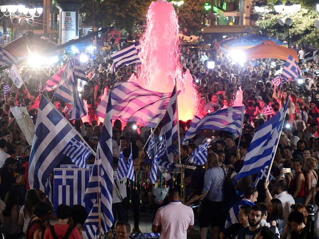 People celebrate in Athens after the first exit-polls of the Greek referendum