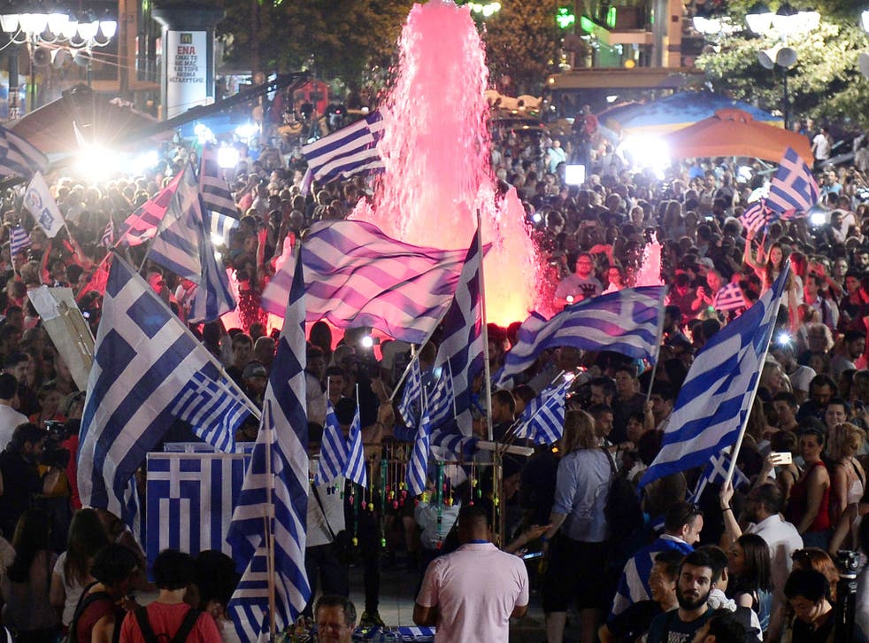 People celebrate in Athens after the first exit-polls of the Greek referendum