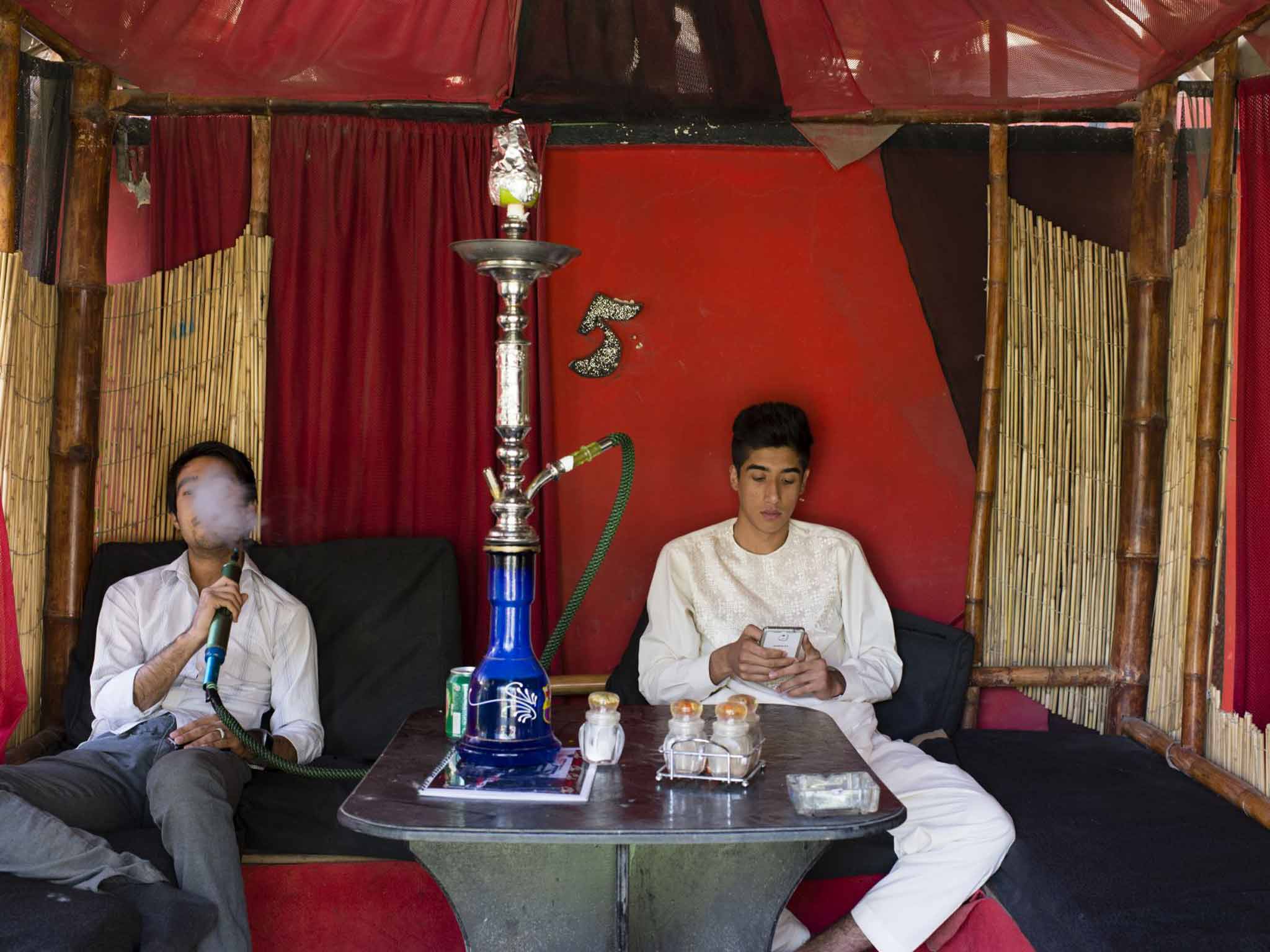 Young men share a hookah in Cafe Che, Kabul