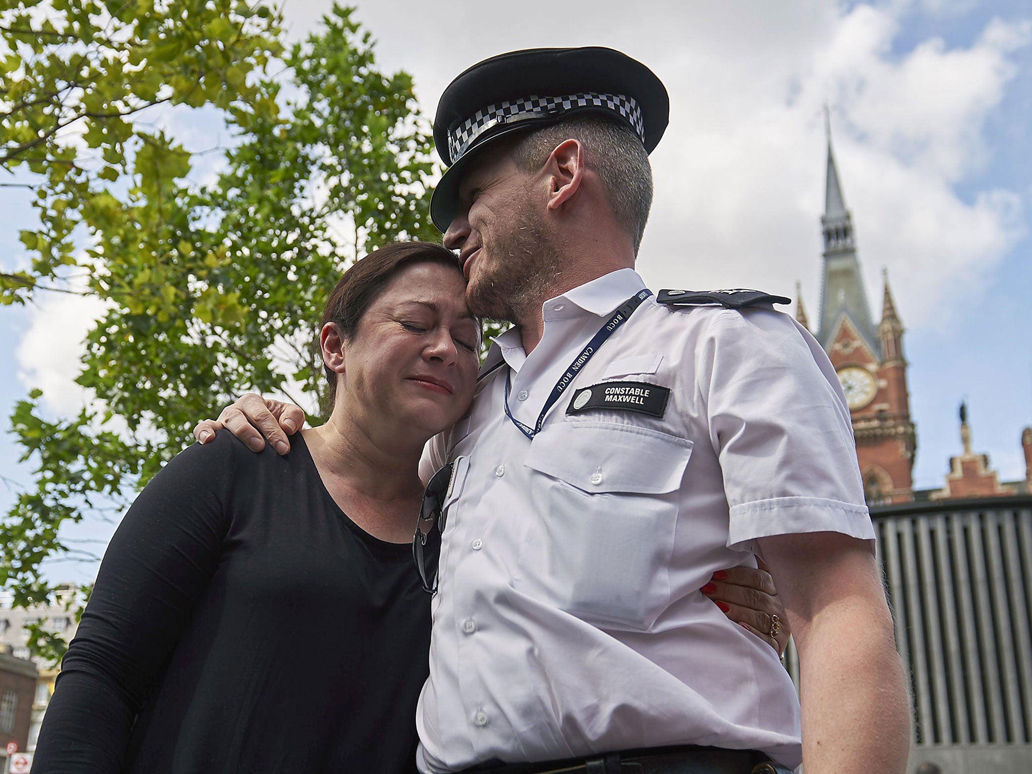 Gill Hicks, (L) a survivor of the 7/7 London terror attacks, embraces police constable Andrew Maxwell outside Kings Cross Station