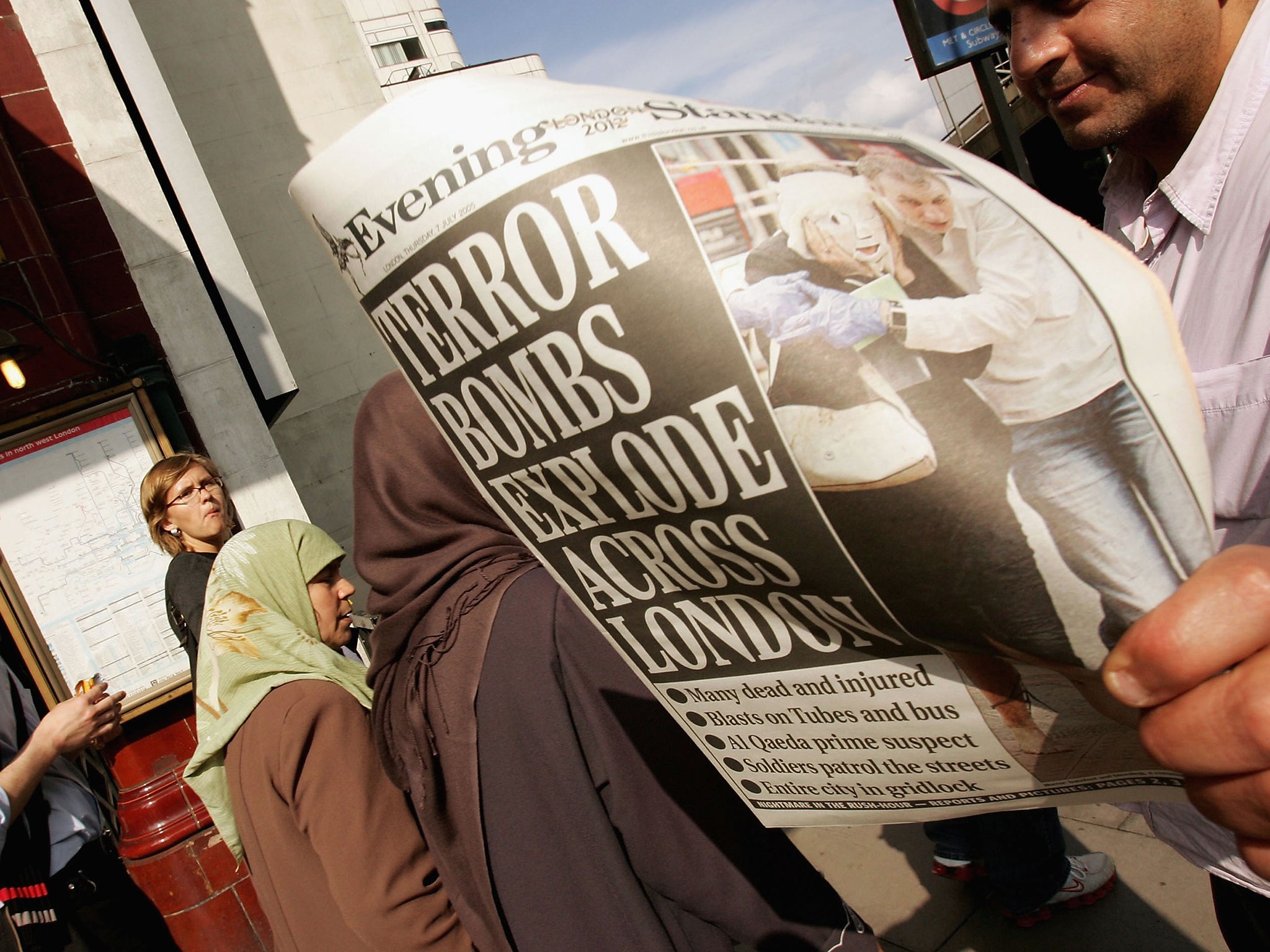 Commuters read newspapers at Edgware Road Underground station the day after the attack