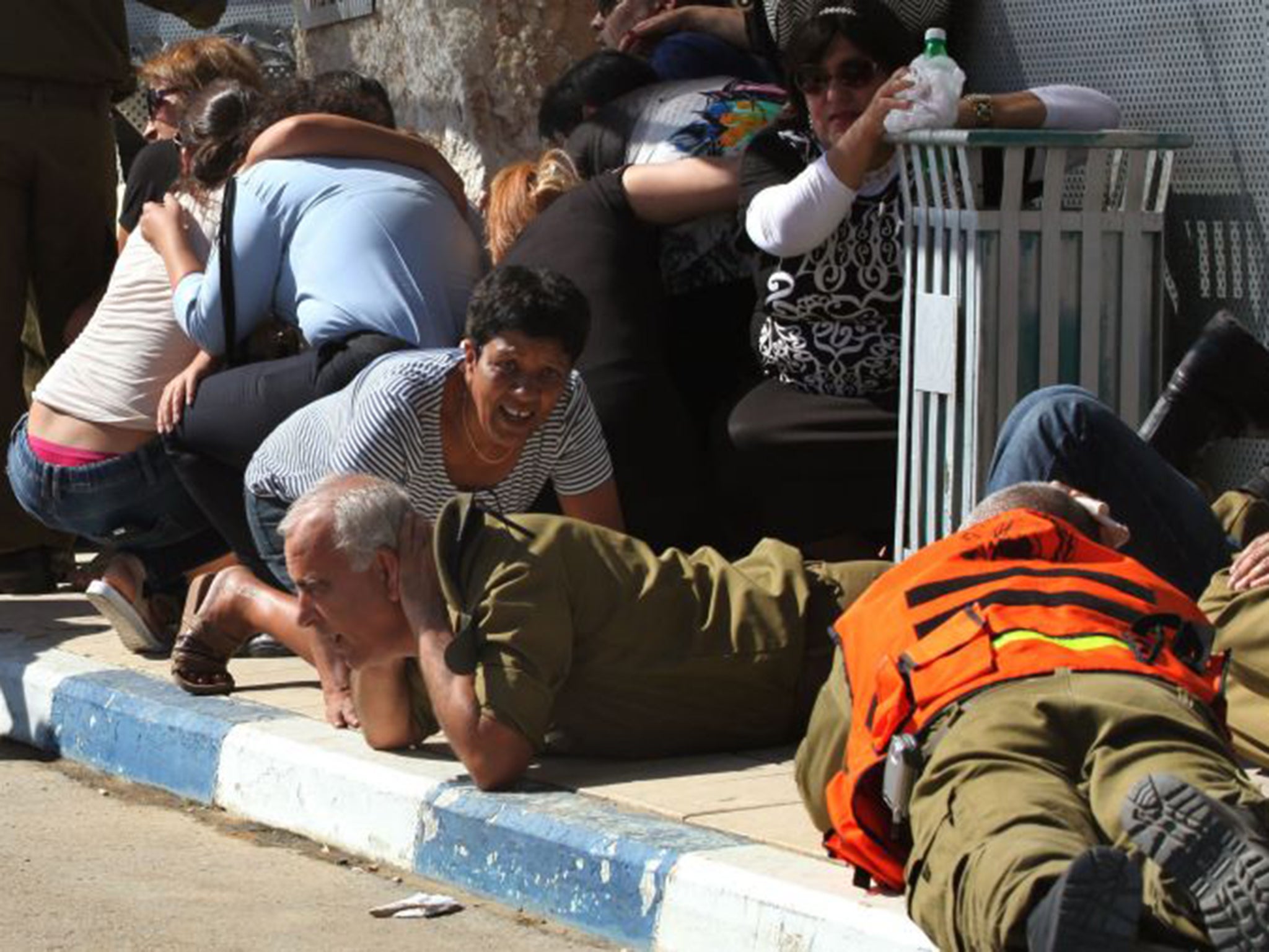 Israelis take cover from a rocket attack from Palestinian militants on the Gaza Strip during the funeral last July of Israeli soldier Corporal Meidan Maymon Biton, 20, killed in a mortar attack