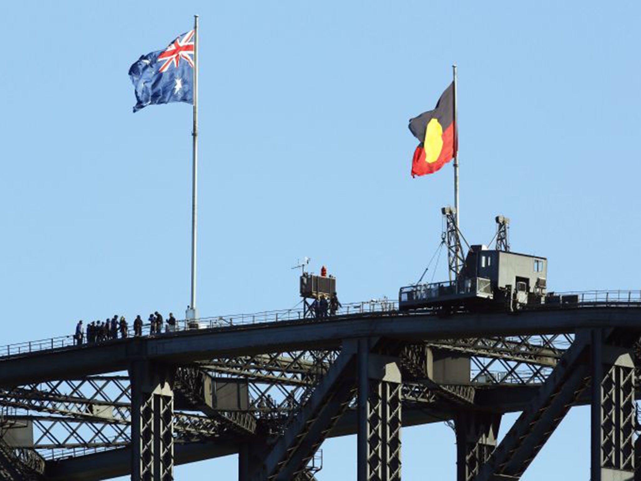 The Australian Aboriginal Flag, right, flies alongside the Australian National Flag on the top of the Sydney harbour bridge