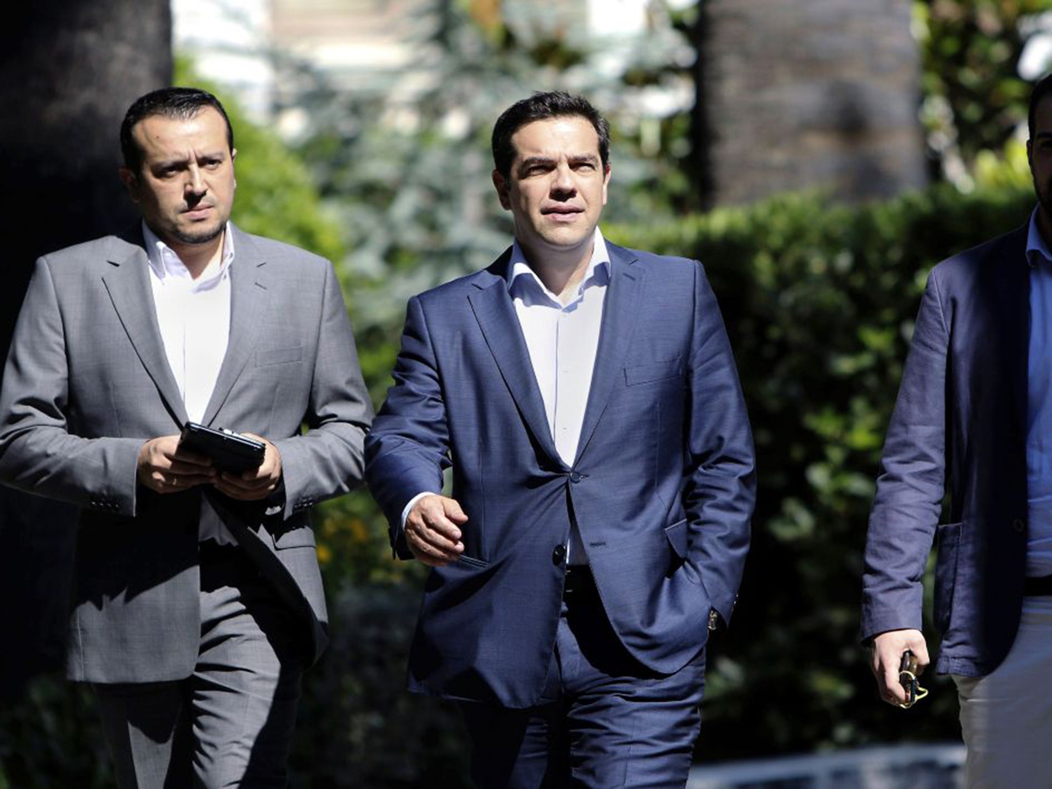 Alexis Tsipras,centre, and a government spokesman leaving the presidential palace in Athens after a meeting of party leaders