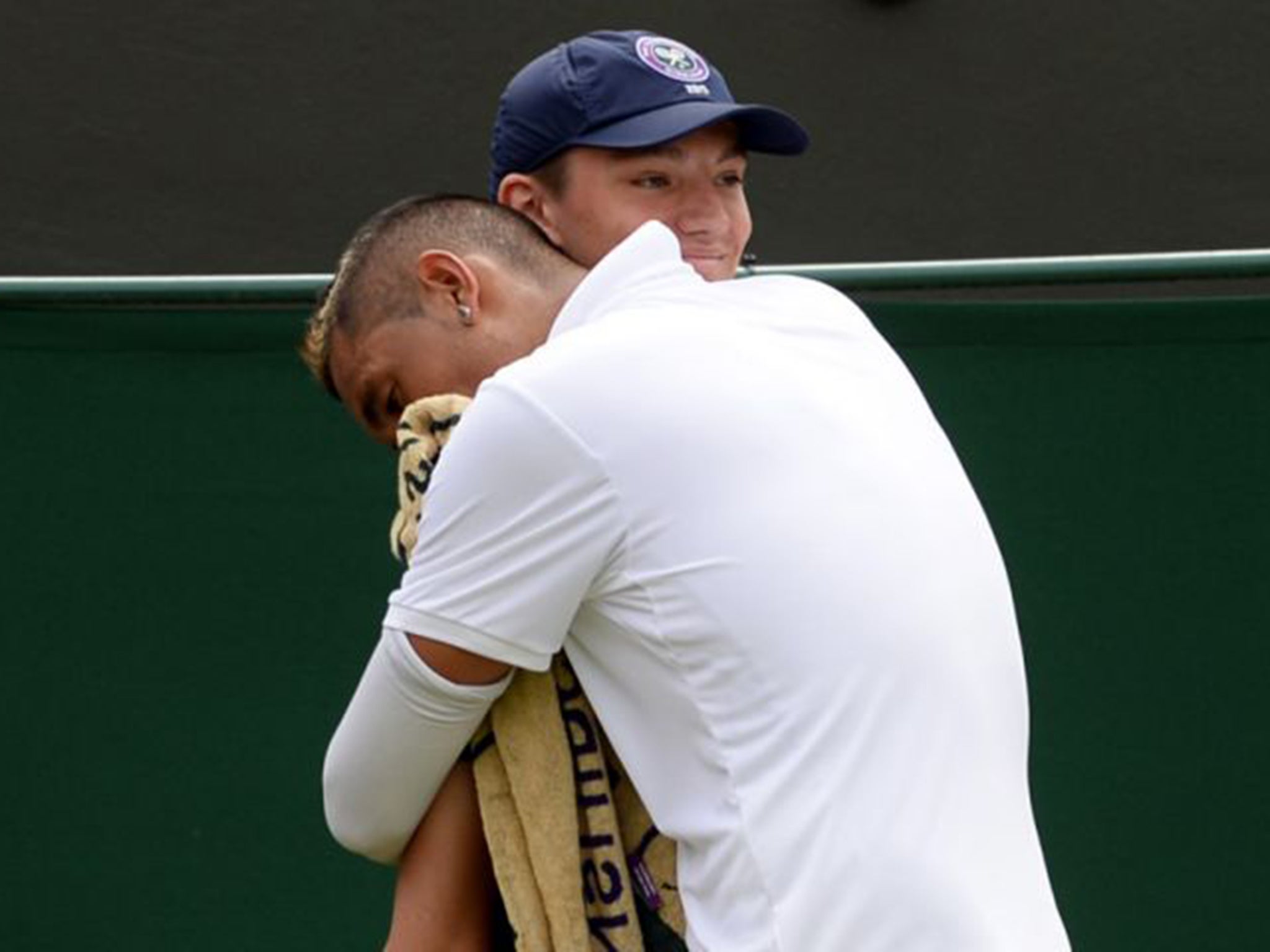 Nick Kyrgios embraces a ball boy during his fourth round match