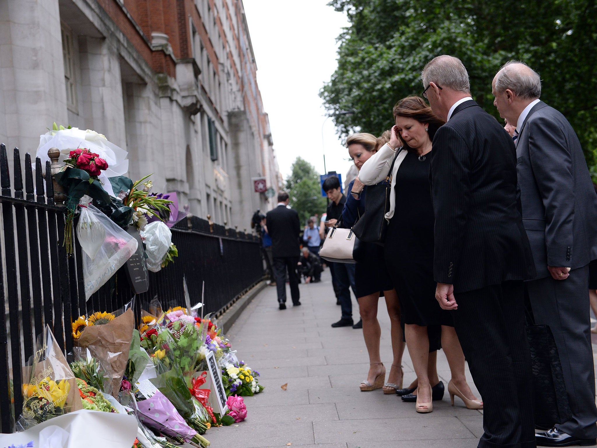People look at flowers left in Tavistock Square