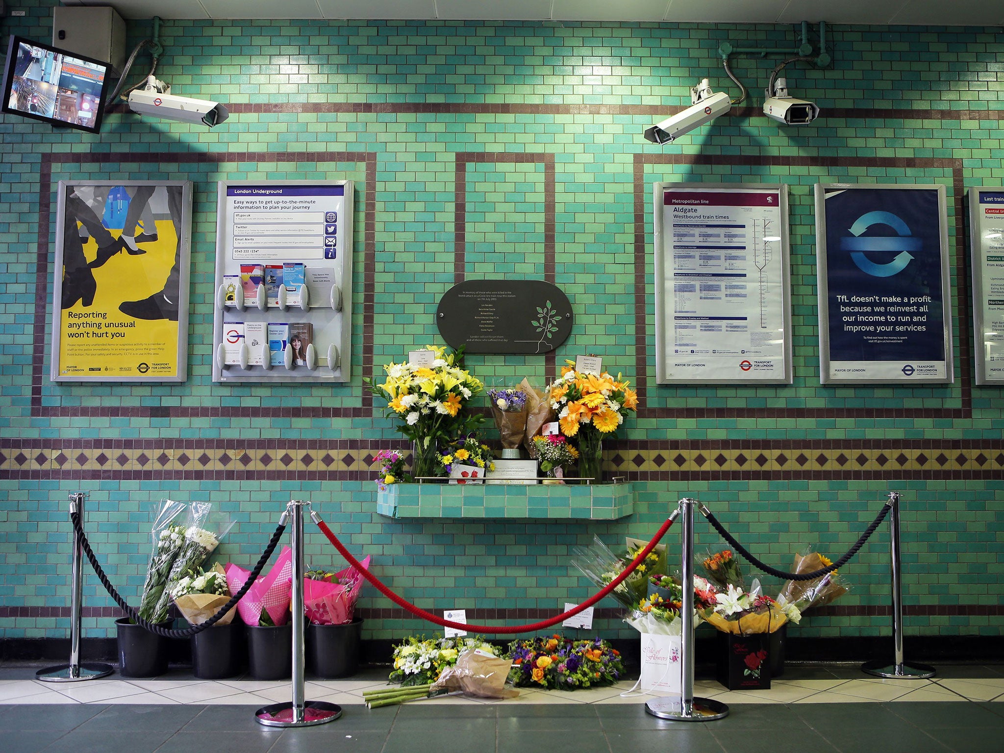 Flowers left by the July 7 memorial plaque at Aldgate Station