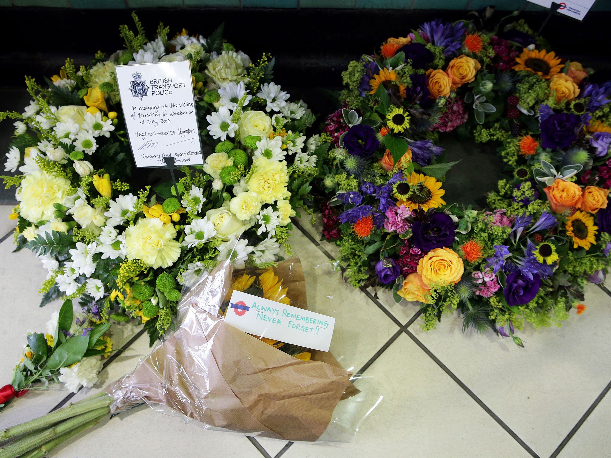 Flowers left by the July 7 memorial plaque at Aldgate Station