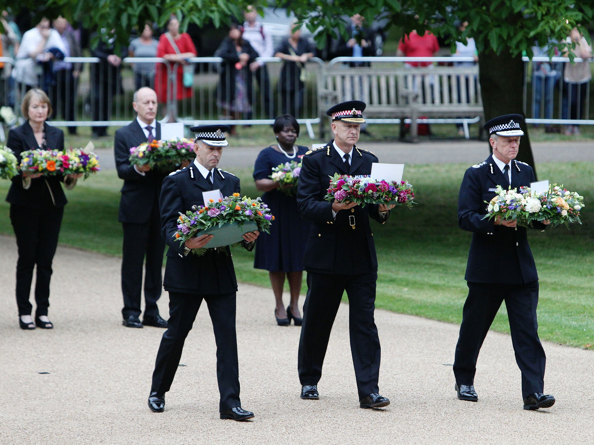 From left: Paul Crowther, Chief Constable, British Transport Police, Adrian Leppard, Commissioner City of London Police, and Sir Bernard Hogan-Howe, Commissioner of the Metropolitan Police, carry wreathes at the July 7 memorial in Hyde Park
