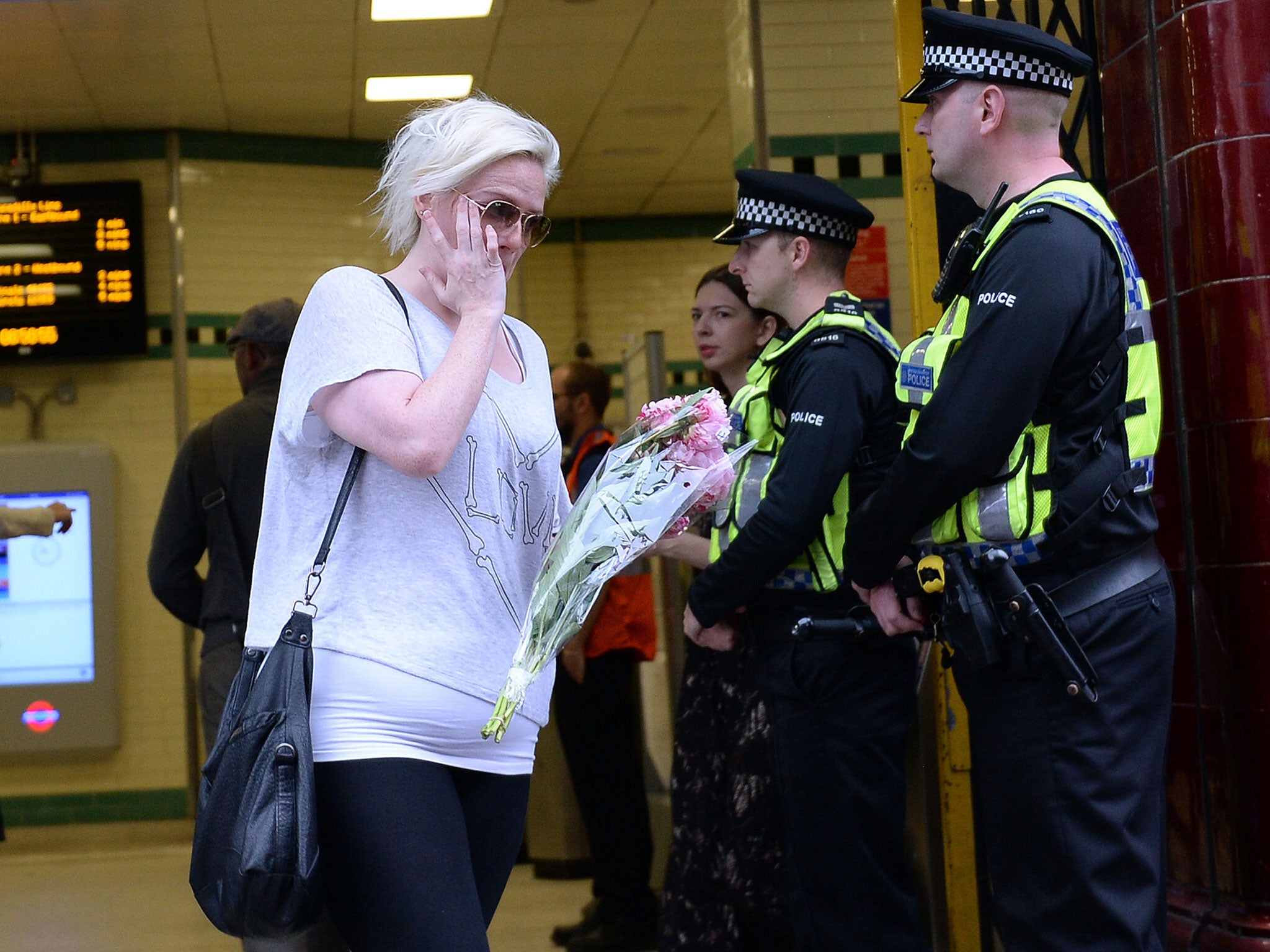 A lady carrying flowers leaves Russell Square tube station