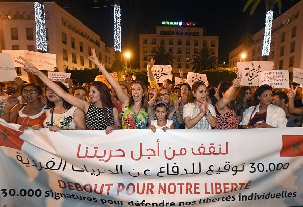 Protesters yesterday hold placards and shout slogans during a demonstration to highlight the plight of the two women arrested for wearing skirts