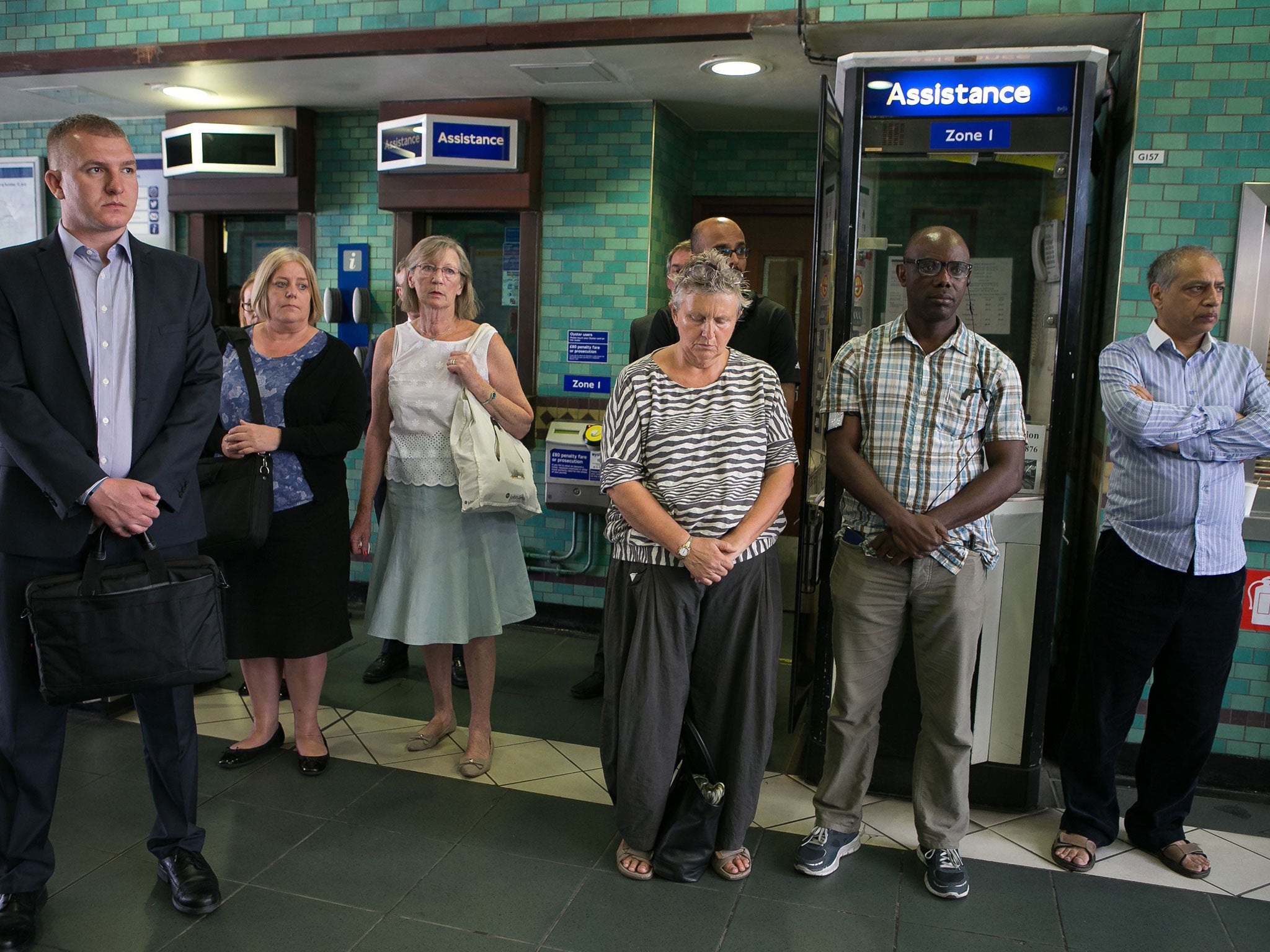 People stop to observe a minute's silence at Aldgate underground station
