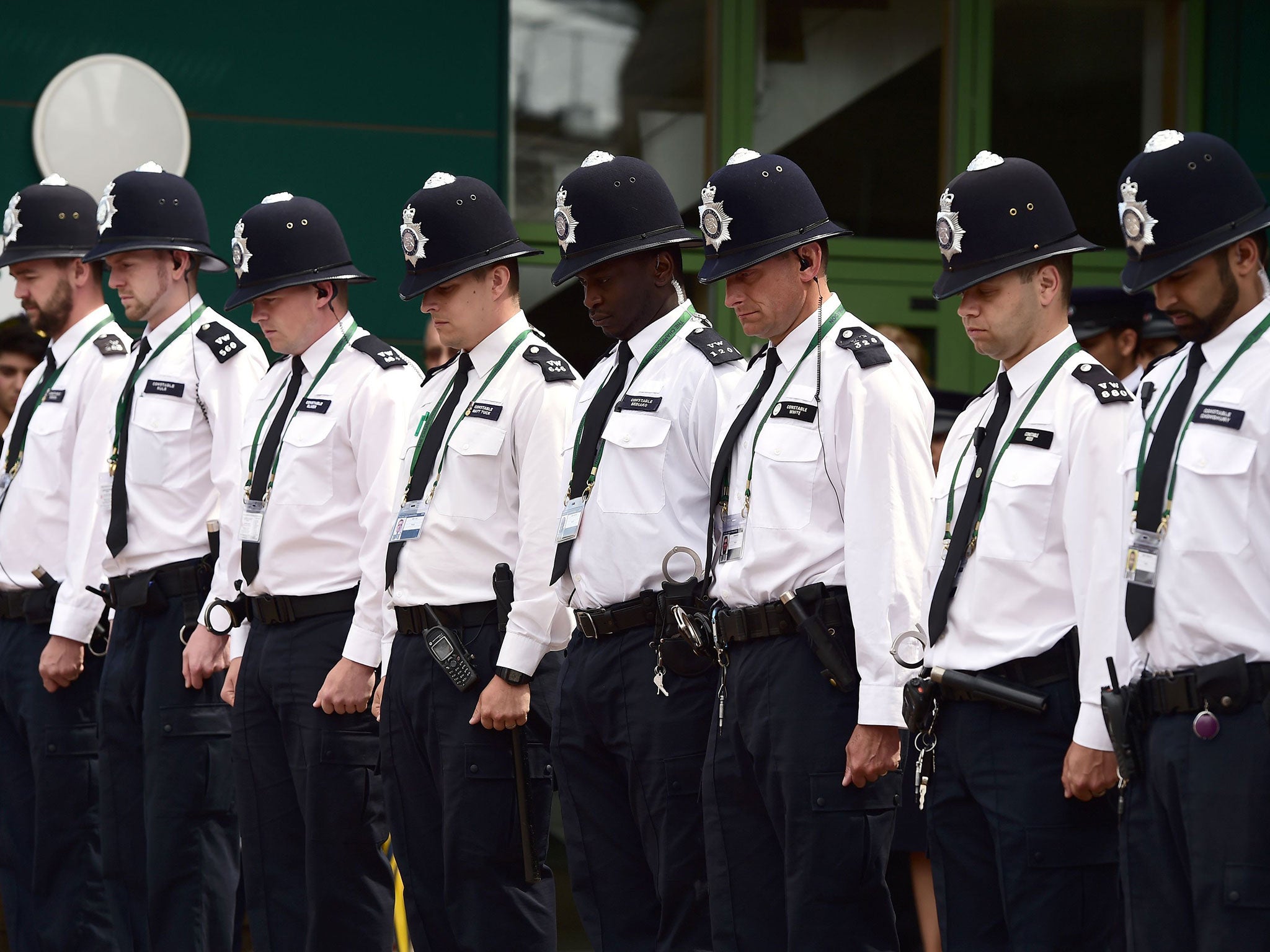 Police officers within the grounds observe a minutes silence