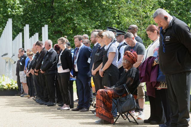 Security staff and workers from Hyde Park observe a minutes silence at the 7/7 memorial in Hyde Park