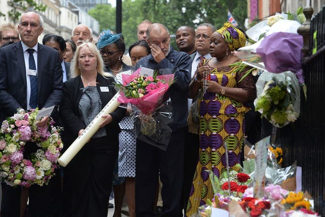 George Psaradakis (centre), the driver of the number 30 bus which was blown up in Tavistock Square, looks at floral tributes left close to the scene of the bombings in London