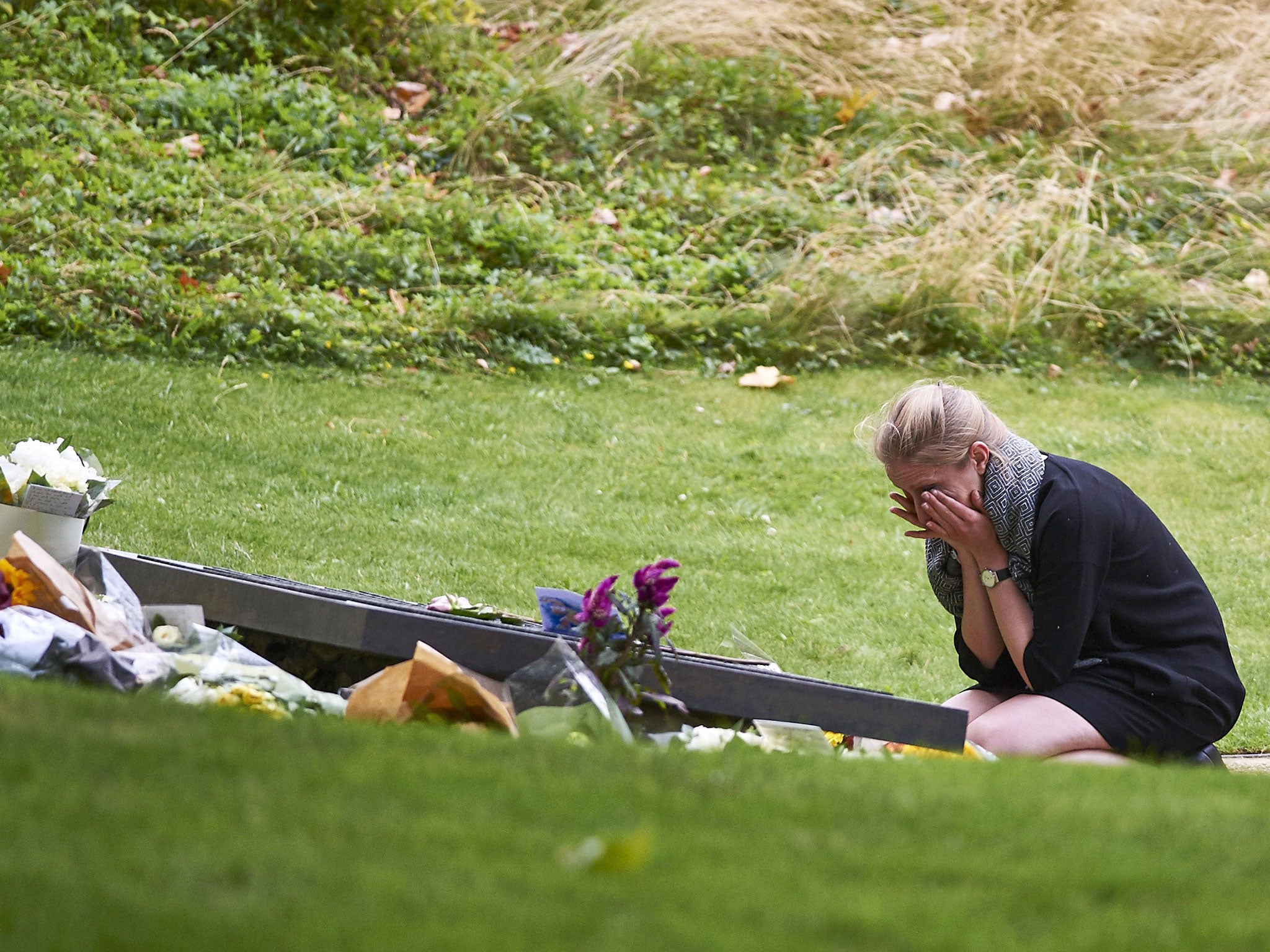 A woman cries at the memorial plaque in London's Hyde Park