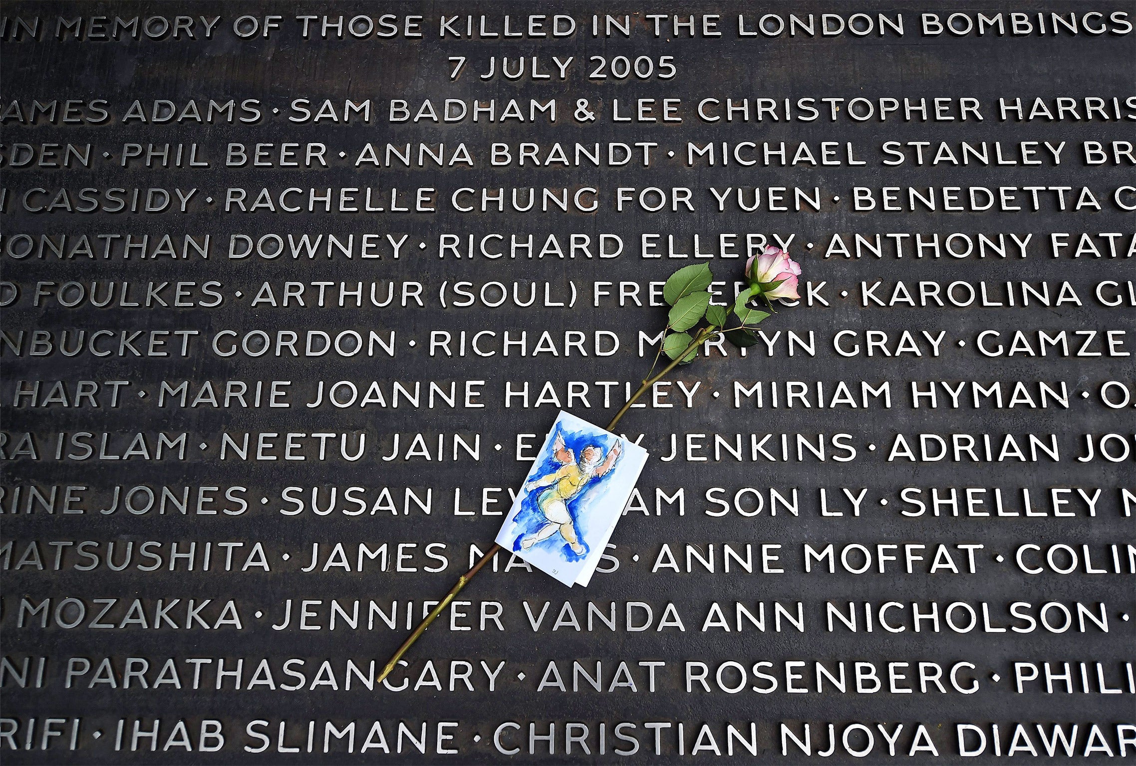 A flower lies on a plaque bearing the names of victims at the 7/7 memorial, on the 10th anniversary of the attacks, in Hyde Park