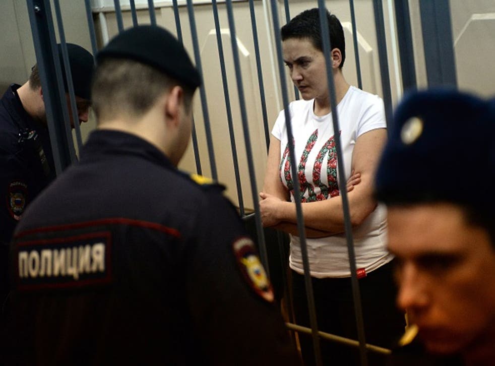 The detained Ukrainian helicopter pilot stands inside the defendant's cage during a hearing in the Basmanny district court in Moscow
