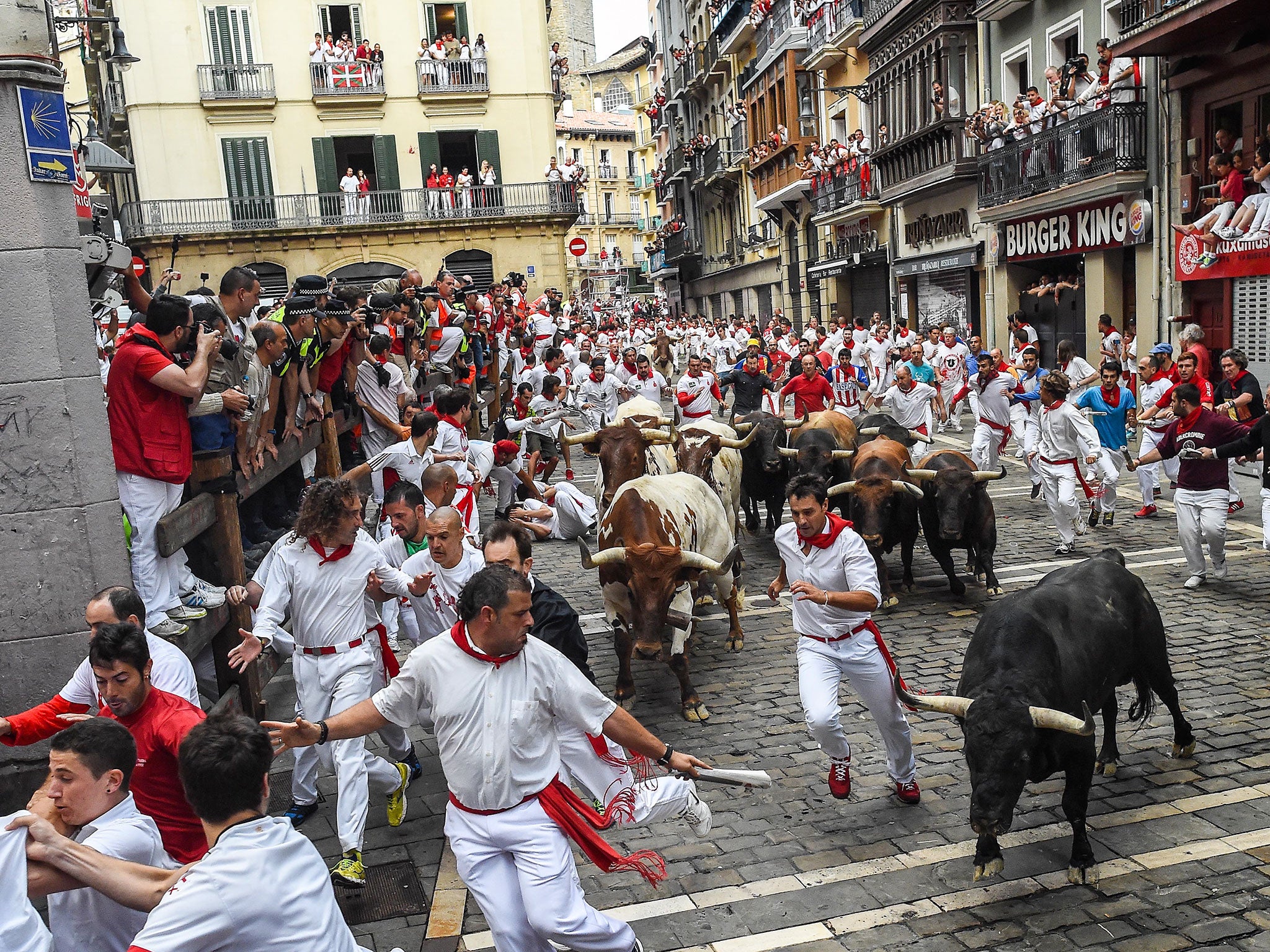 Revellers run with the Tajo and the Reina's fighting bulls entering Estafeta street