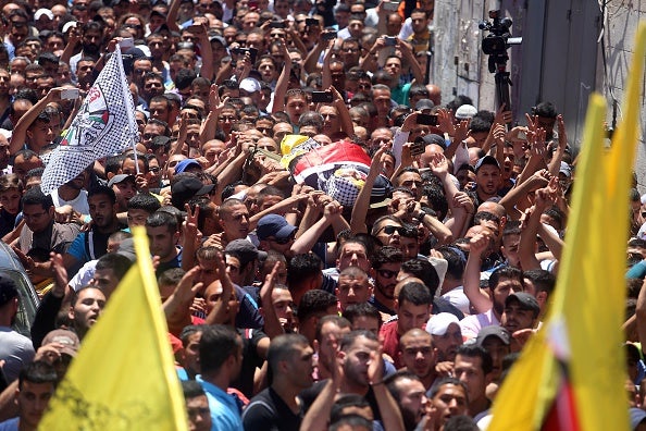Hundreds of mourners escort the body of Muhammad al-Kasbeh at a funeral ceremony on July 3 in Ramallah
