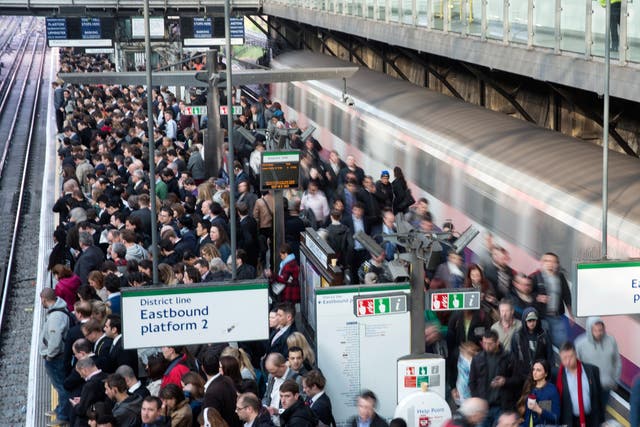 Commuters prepare to travel on the District Line of the London Underground which is running a limited service due to industrial action on 30 April 2014 in London, England