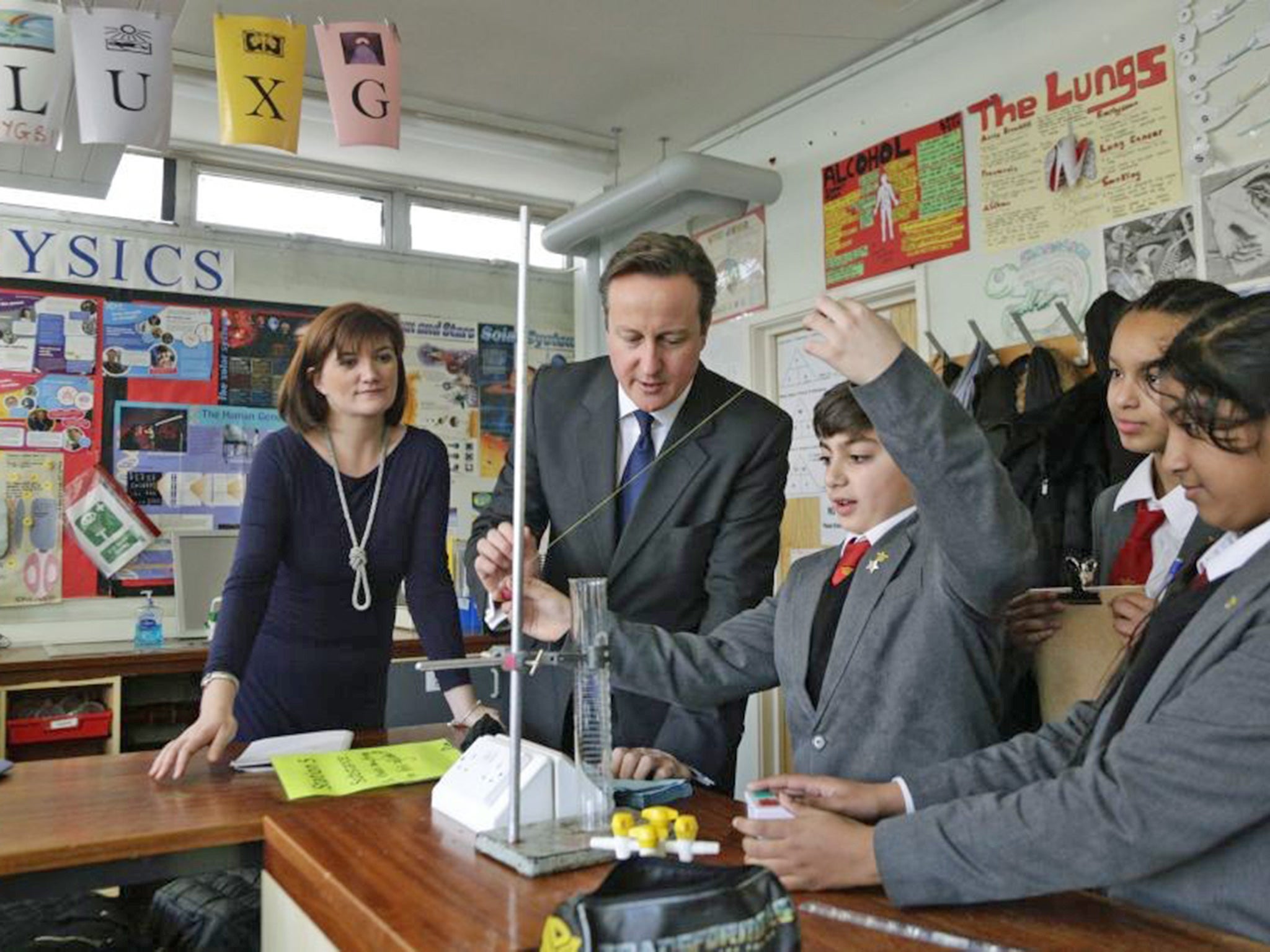 Prime Minister David Cameron and Education Secretary Nicky Morgan taking part in an experiment in a science classroom with pupils