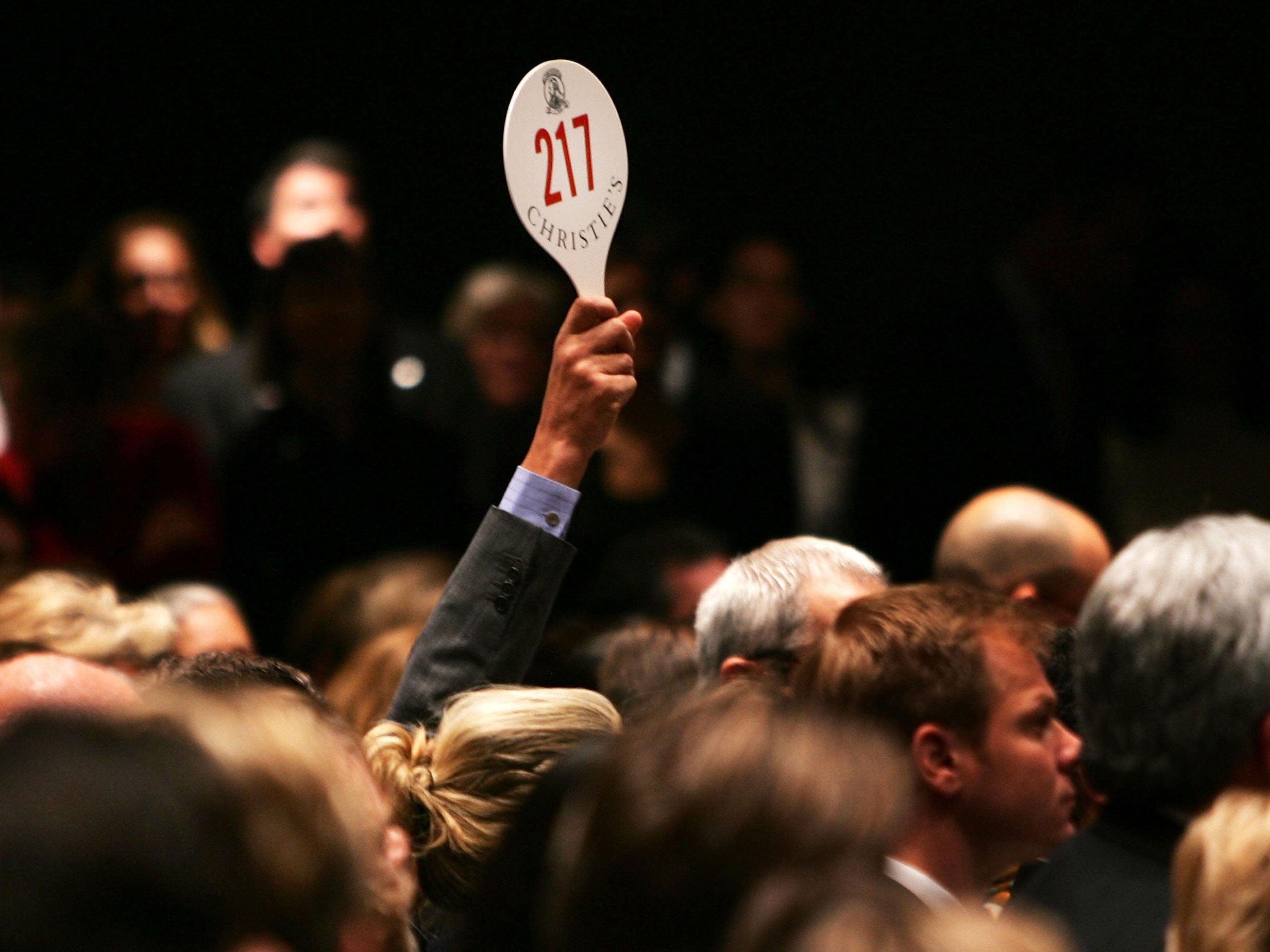 A man bids at an auction at Christie's in New York, which was not involved in the French scandal