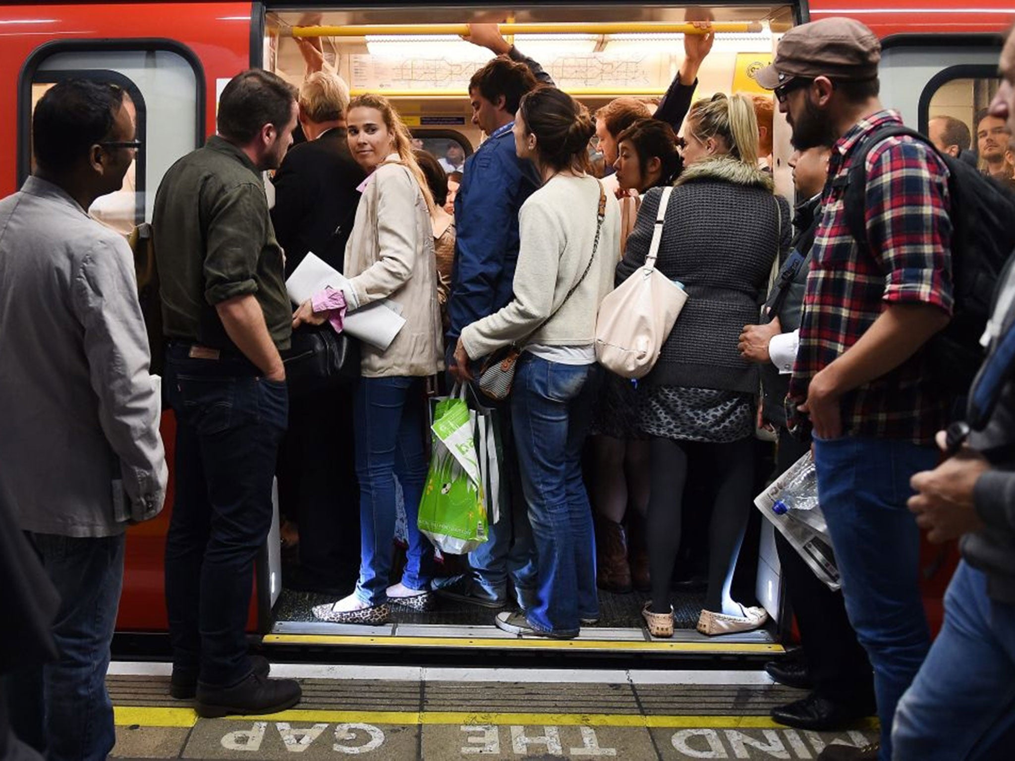 Commuters try to get onto a tube train at Westminster station in London