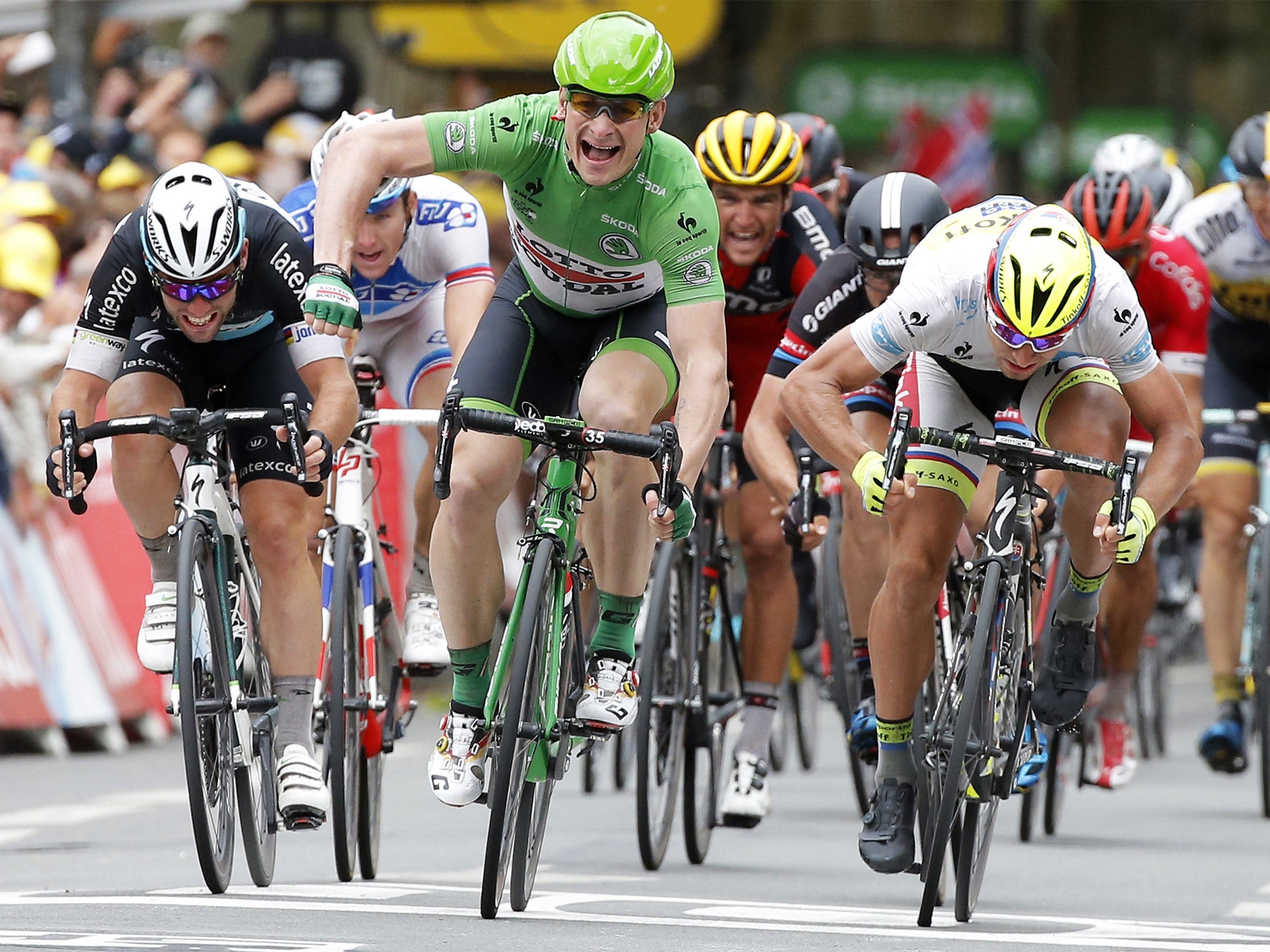 André Greipel starts to celebrate as he crosses the finish line ahead of Mark Cavendish (left) and Peter Sagan (right) to win the fifth stage of the Tour de France
