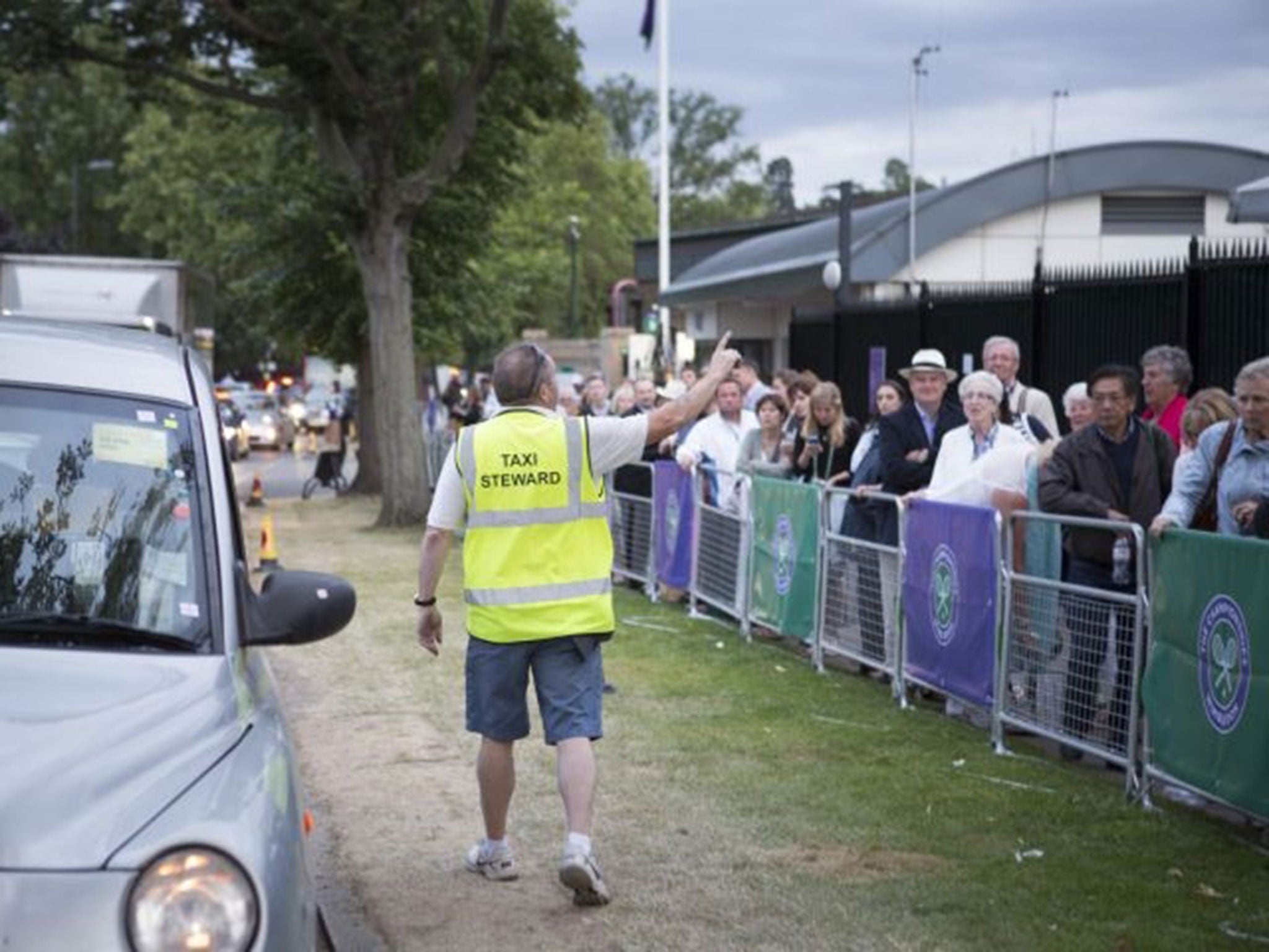 People wait in line for taxis in Wimbledon, south west London, as tennis fans leaving the All England Club faced a difficult journey home due to a Tube strike which will cripple services until Friday morning.