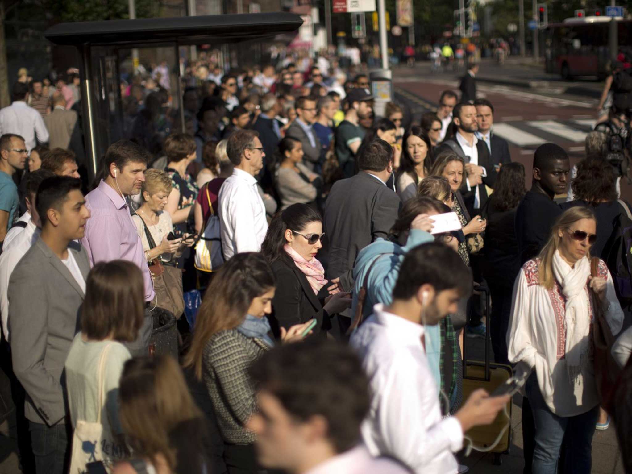 Londoners queue for a bus this morning